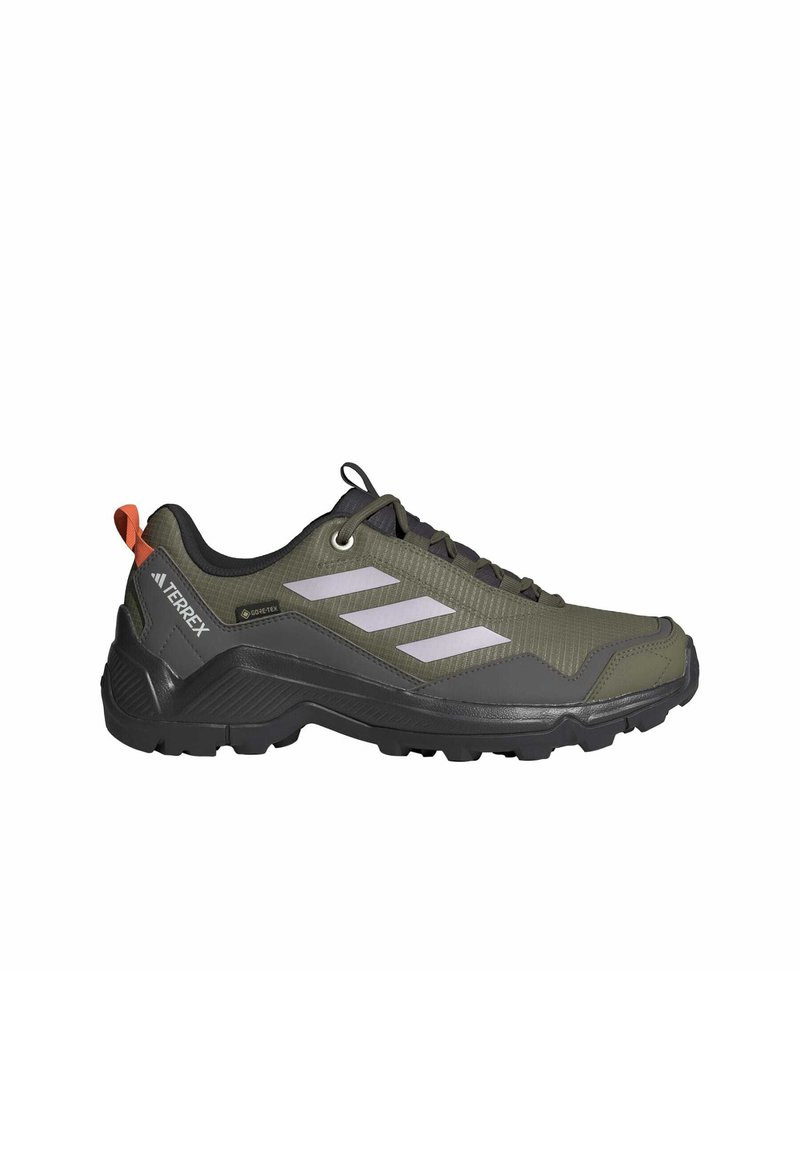 Zapatos de senderismo verdes y negros con parte superior texturizada, diseño de tres rayas blancas, suela de goma y una pestaña trasera con un acento naranja.