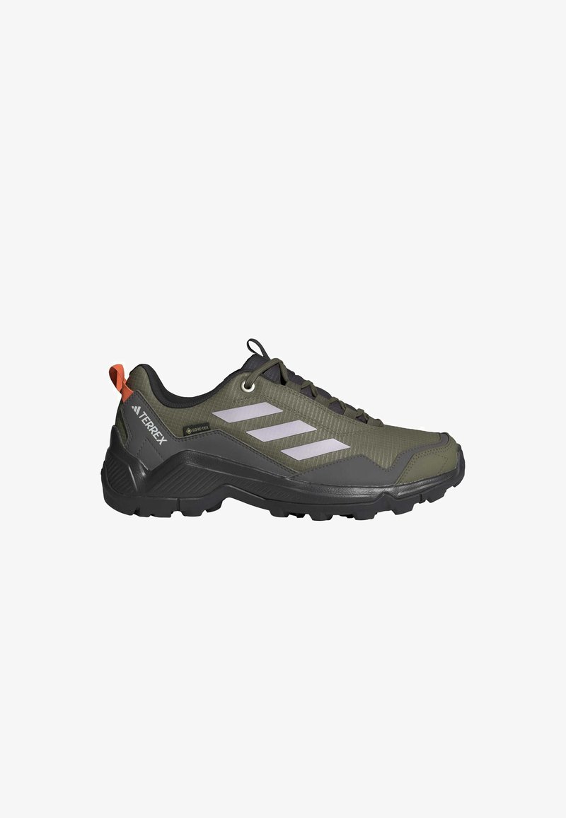 Zapatos de senderismo verdes y negros con parte superior texturizada, diseño de tres rayas blancas, suela de goma y una pestaña trasera con un acento naranja.