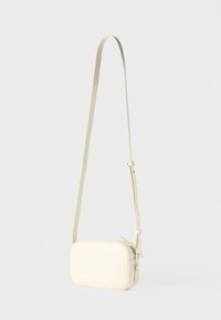 Ristkülikukujuline kreemika värvusega nahast õlakott, millel on pikk reguleeritav rihm, tõmblukuga sulgemine ja minimalistlik disain. Sile tekstuur, ilma kaunistusteta.