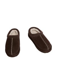 Pantofole in suede marrone con una morbida fodera in pelliccia bianca, punta arrotondata e cuciture decorative lungo la tomaia. Suola piatta in gomma.