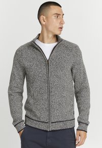 Pullover zip grigio e nero con texture, colletto alto, polsi e orlo a costine, con zip a contrasto e un sottile motivo a maglia.
