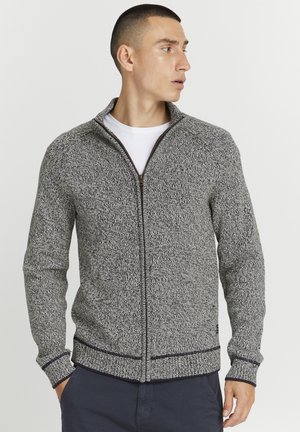 Sudadera con cremallera en gris y negro, texturizada, con cuello alto, puños y bajo acanalados, que presenta una cremallera en contraste y un sutil patrón de punto.