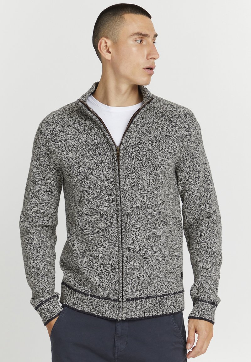 Pullover zip grigio e nero con texture, colletto alto, polsi e orlo a costine, con zip a contrasto e un sottile motivo a maglia.