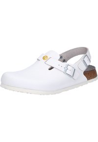 White clogs with a closed toe, adjustable strap, and a cork accent on the heel. Smooth synthetic material and rubber sole with textured pattern.