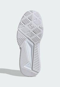 Biała podeszwa buta sportowego z teksturowaną gumową powierzchnią, z wzorem jodełki i akcentem logo, kanciasty design z wieloma rowkami.