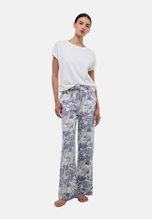 T-shirt blanc à manches courtes associé à un pantalon ample à motifs floraux dans des nuances de bleu et de blanc, avec une taille élastique et un cordon de serrage.