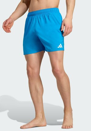 Blaue Sportshorts mit einem elastischen Bund, glatter Textur und einem weißen Logo-Detail. Bemerkenswert ist das Design in mittellanger Länge bis zur Oberschenkelmitte.