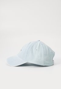 Gaiši zila denim cepure ar izliekto vizieri, sešām ventilācijas acīm un mazu logotipu priekšā. Mīksta tekstūra un ikdienišķs dizains.