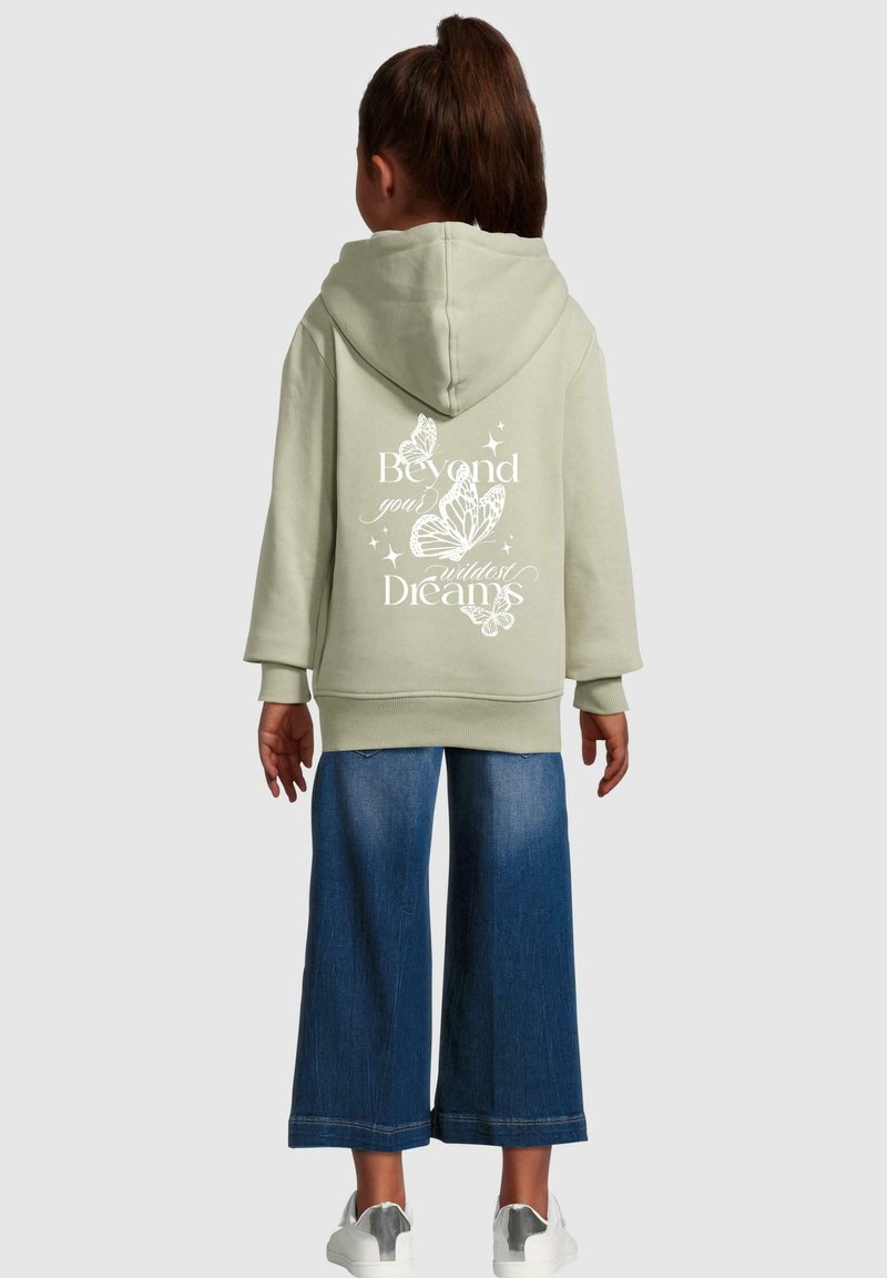 Olive green hoodie with a large butterfly graphic and text on the back, paired with wide-leg blue jeans and white sneakers.