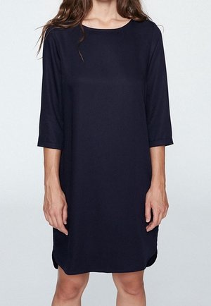 Robe bleu marine, longueur genou, avec des manches trois-quarts, col rond, fentes latérales, en tissu lisse, coupe décontractée.