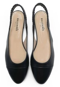 Zapatos slingback de cuero negro con punta redondeada, forma de almendra y acentos trenzados en el tacón. Textura suave con plantillas beiges.