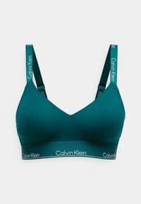 Fekete színű bralette V-nyakú kialakítással, puha anyagból készült. Állítható pántokkal rendelkezik, rajta a "Calvin Klein" márkajelzéssel és széles alsó pánttal.