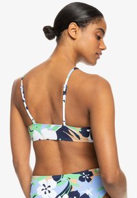 Blumenbikinioberteil mit verstellbaren Trägern, einem bunten Design mit blauen, grünen und weißen Akzenten sowie einer bequemen Passform für Wasseraktivitäten.