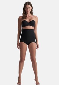 Czarny biustonosz bikini bez ramiączek w połączeniu z wysokim stanem majtek bikini. Gładka tekstura, bezszwowy design i minimalistyczny styl bez ozdób.