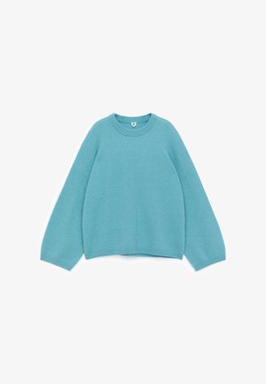 Light blue sweater made of soft fabric, featuring a round neckline and dropped shoulders, with ribbed hem and cuffs.