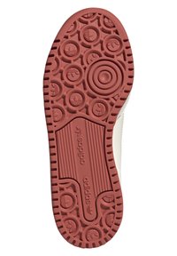 Gummisulor i röd färg med texturerade cirkulära mönster och skåror, med Adidas-logotypen präglad på en central panel.