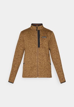 Brown fleece jacket with a zippered front, high collar, and contrast navy accents. Features a logo on the upper left side and side pockets.