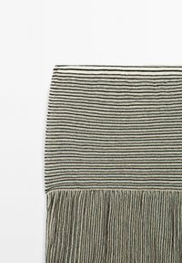 Gestreiftes Blanket mit horizontalen schwarzen Linien auf einem hellen Hintergrund, mit fransigen Kanten und einer strukturierten Oberfläche.