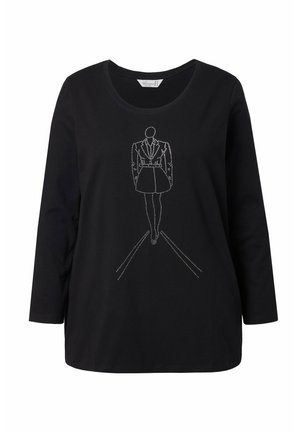 Maglietta nera a maniche lunghe con un disegno in filo bianco che rappresenta una figura con giacca e gonna, con linee dritte sottostanti che rappresentano un percorso.