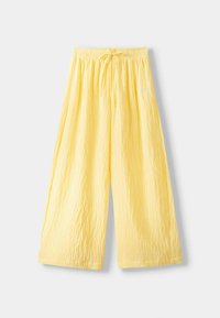 Gula vida byxorna i lättviktig, texturerad tyg med vertikala ränder och ett elastiskt midjeband med en knytning.
