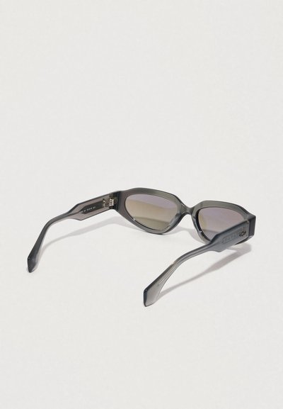 Gafas de sol con un marco de plástico gris, lentes rectangulares ligeramente sobredimensionados y varillas delgadas con sutiles detalles de marca.