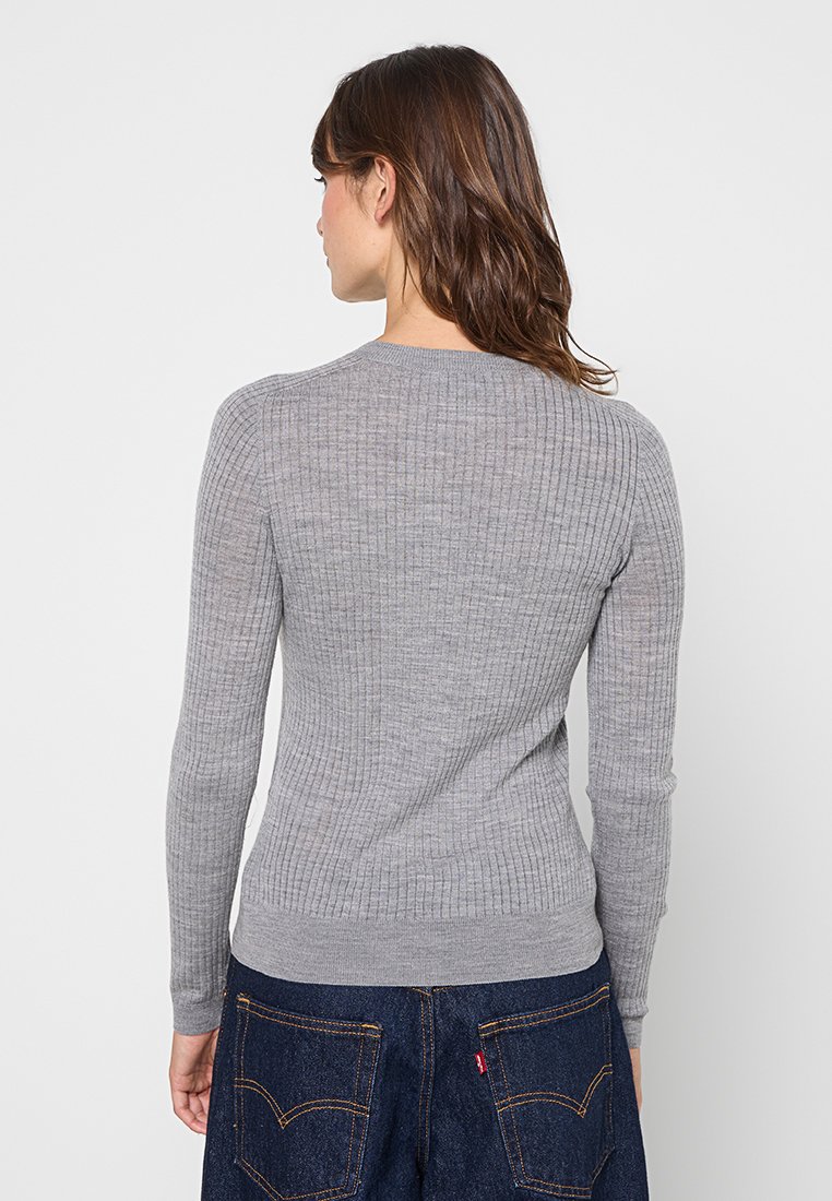 Grauer, gerippter Pullover mit langen Ärmeln und rundem Halsausschnitt, der ein tailliertes Design und ein strukturiertes Strickmaterial aufweist.