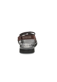 Sandale marron avec une sangle texturée, un dos ajustable et une semelle noire. La semelle intérieure arbore un logo et le design est ouvert à l'avant pour plus de respiration.