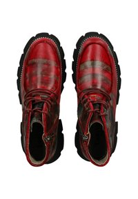 Botas de cuero rojo con un acabado texturizado, costuras en zigzag, punta redonda y suelas negras gruesas. Los acentos incluyen herrajes metálicos y cordones.