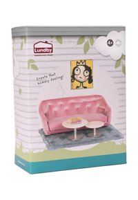 Pink velvet sofa with tufted design, two round tables, and a blue rug. Box features cartoon art and green leaf accents on a wooden background.