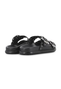 Chanclas negras con dos correas anchas que tienen grandes hebillas de metal y múltiples perforaciones. La suela es texturizada y ligeramente elevada.