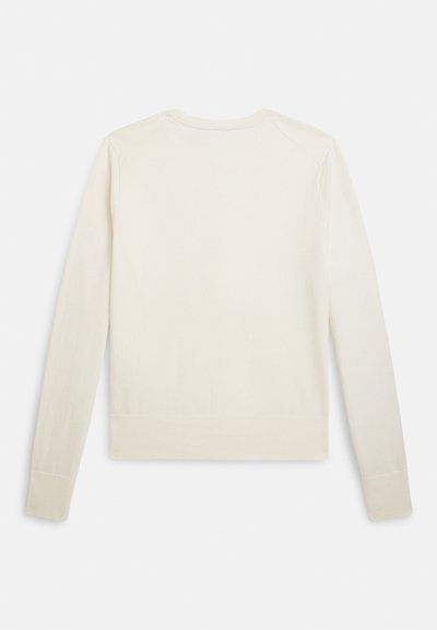 Ilgas rankovėmis megztinis kreminės spalvos, su apvalia iškirpte ir ribuotu apačios kraštu. Lygios tekstūros, prigludusios silueto, be matomų papuošimų.