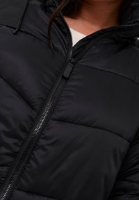 Black puffer jacket with a zip closure, featuring a quilted texture and an adjustable hood. Smooth fabric with matte finish.