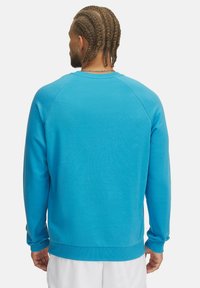 Turkoois sweatshirt met een ronde halslijn, lange mouwen en geribbelde manchetten en zoom. Glad materiaal, met een uniforme kleur zonder patronen.
