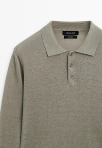 Polo manches longues vert olive clair avec col et trois boutons, en tissu de lin.
