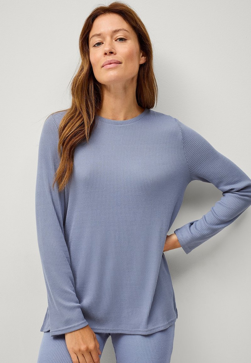 Maglione a maniche lunghe in morbido tessuto blu chiaro a coste, con scollo rotondo, vestibilità rilassata e spacchi laterali per una maggiore libertà di movimento.