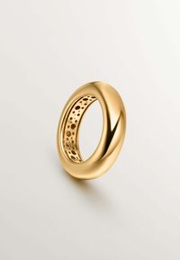 Anillo de oro con un exterior liso y pulido y un centro hueco que presenta un diseño perforado. Forma circular, reflejando la luz.