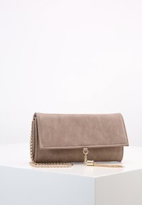 Beige kabelka z faux kůže s přehybem, zlatým řetízkem a detailem v podobě třásně. Hladká textura a minimalistický design.