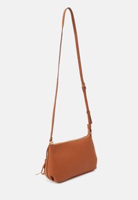 Brun crossbody-taske i imiteret læder med en lang justerbar rem, gyldent lynlås og glat tekstur, med et minimalistisk design og rund bund.