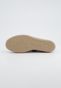 Soletta di scarpa marrone con motivo testurizzato per la presa, con il logo "Paul Green" impresso. Colore beige chiaro e design arrotondato, funzionale e antiscivolo.