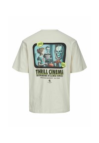 Cremefarvet t-shirt med korte ærmer, der har et retrografik af skeletter og græskar, med teksten "THRILL CINEMA" og grønne accentklistermærker.