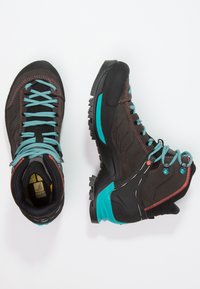 Black hiking boots with turquoise accents, featuring a textured upper, sturdy sole, and contrasting red stitching. Lightweight and durable design.