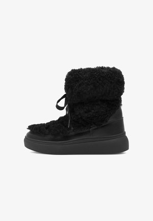 Czarne botki za kostkę z futrzastą teksturą na cholewce, skórzanymi akcentami, okrągłym noskiem i grubą czarną podeszwą z prostym sznurowaniem.