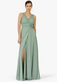 Minzgrünes Abendkleid mit V-Ausschnitt, gefälteltem Oberteil und fließendem Rock mit einem hohen Schlitz bis zum Oberschenkel. Glattes, leichtes Material.