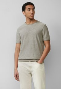 Lichtbruine gestreepte t-shirt met korte mouwen en een ronde halslijn, gecombineerd met crèmekleurige broek. Zachte textuur en relaxed fit.