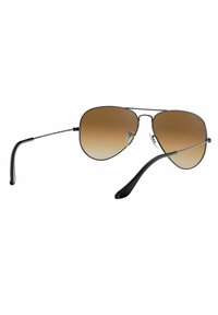 Occhiali da sole aviator con lenti a gradiente marrone, aste in plastica nera e montatura metallica, dotati di naselli regolabili per una vestibilità sicura.