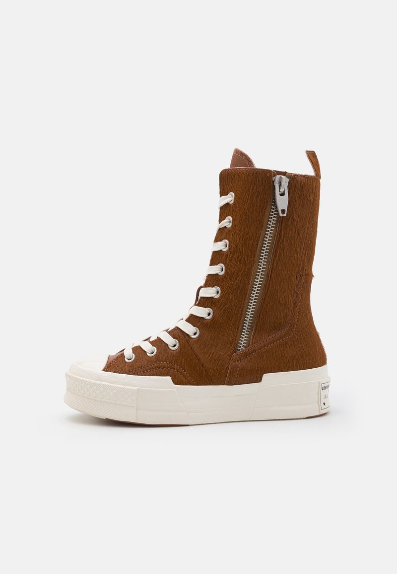 Pruuni kõrged tossud tekstureeritud kangast, valged paelad, külgmine lukk ja paks valge tald, ruudukujulise varba ja logodetailiga.