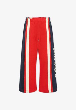 Rode joggingbroek met verticale strepen in marineblauw en crème. Bevat een elastische tailleband en zijzakken. Inclusief tekstdetails aan één zijde.