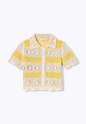 Cardigan court en crochet avec des rayures en dentelle florale jaune et beige, fermeture à boutons sur le devant et col pointu.