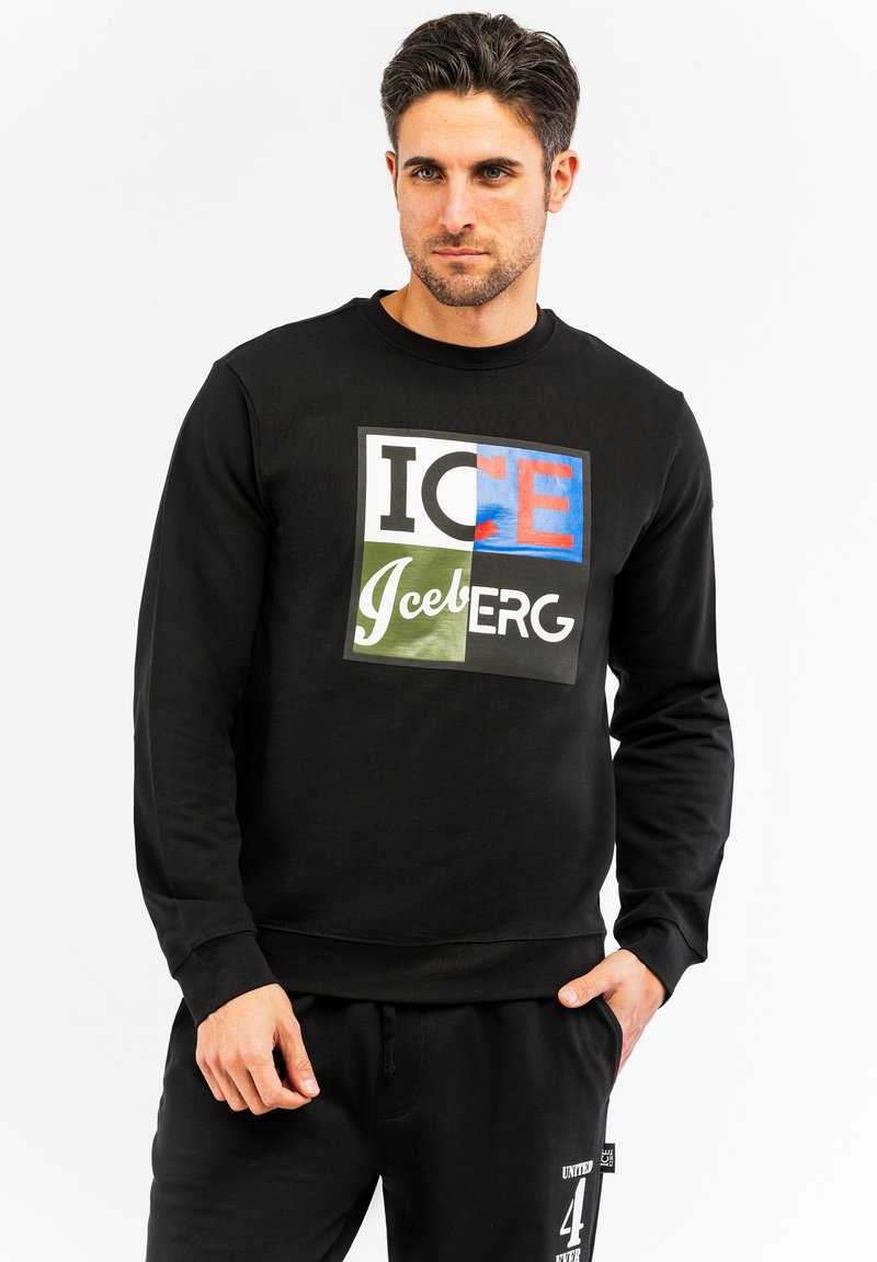 Crna dukserica s prednjim šarenim grafičkim prikazom s natpisom "ICE IceBERG." Ima klasičan okrugli izrez i rebraste rukave. Materijal od mješavine pamuka.