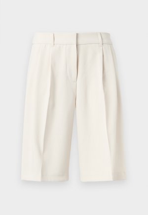 Roomkleurige, op maat gemaakte shorts tot op de knieën met riemlussen en voorplooien, weergegeven tegen een effen witte achtergrond.